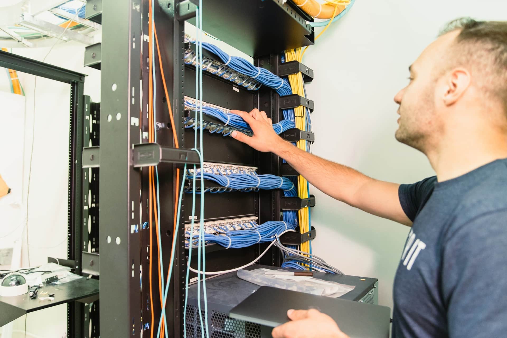 Suzor IT technician organizing patch panels and cabling in an MDF rack