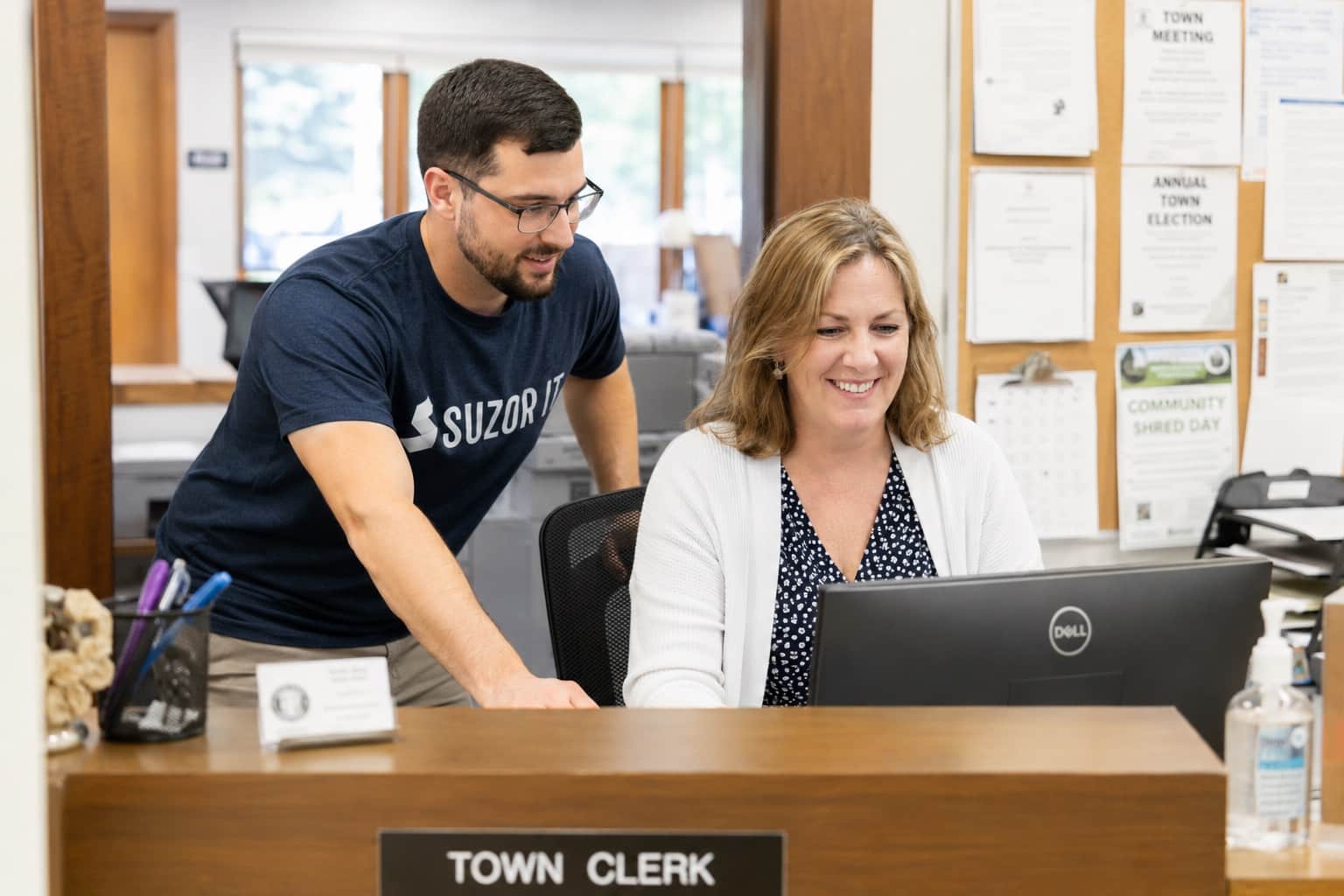 Suzor IT technician helping a town clerk at her front counter